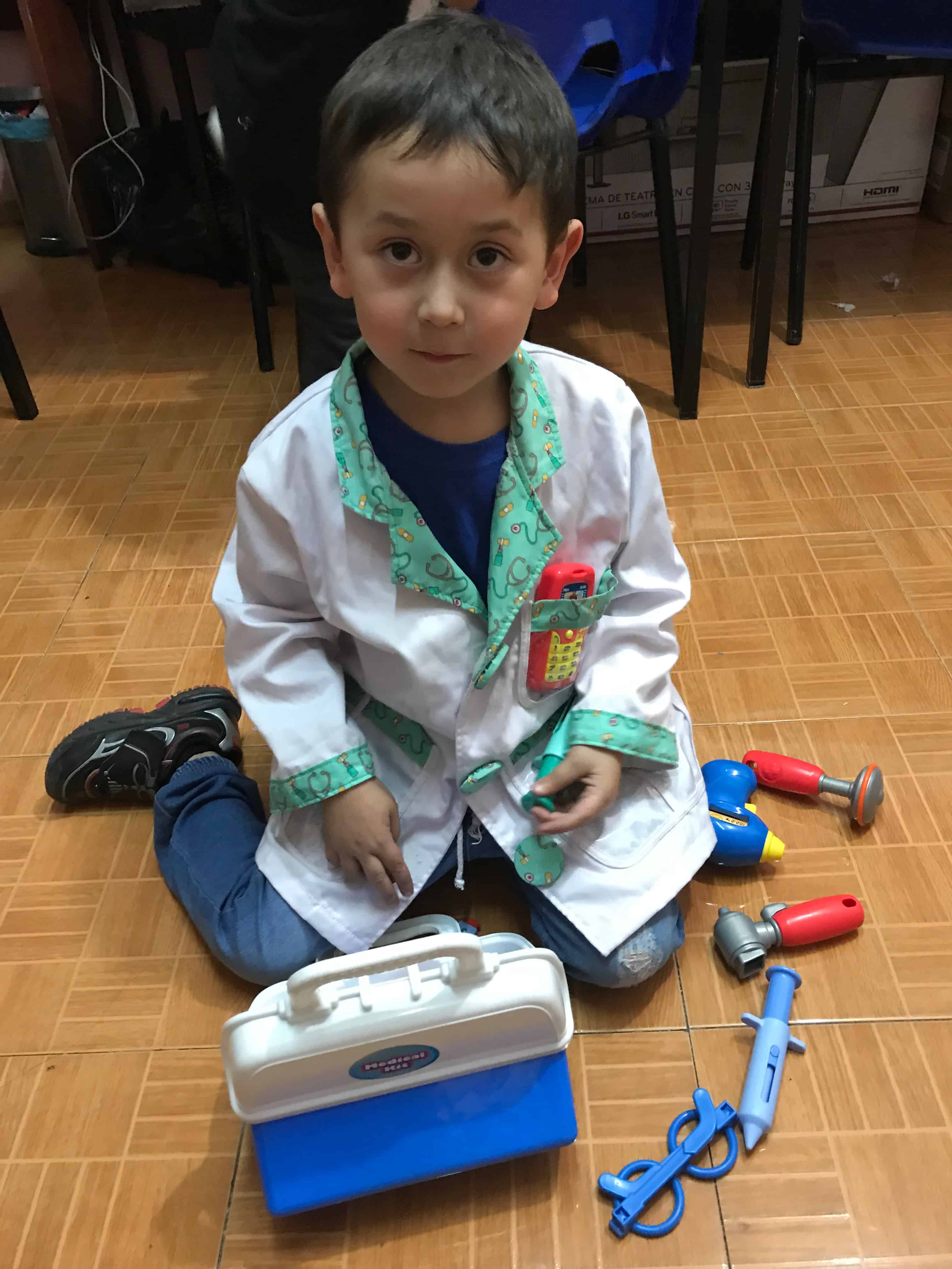 Niño con bata blanca de doctor, beneficiario de Audio Amigo