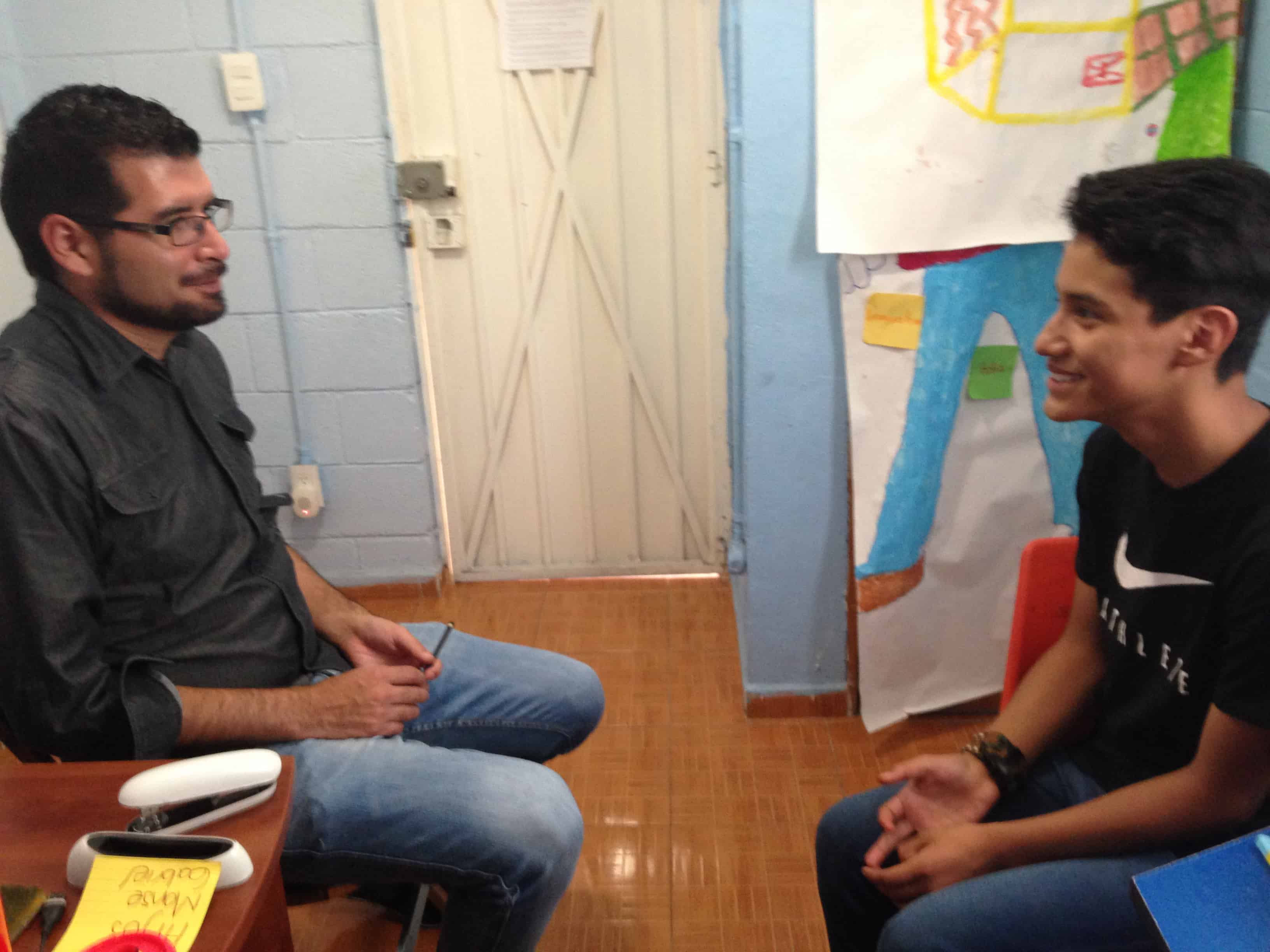 Adolescente conversando con un psicólogo durante una sesión de atención psicológica